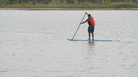 Native man standing on board while paddling with stick on shambhavi river, Mulki Stock Footage 145046715