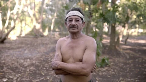A native mayan adult man is posing shirtless wearing a paliacate in the jungle Stock Footage 221785043