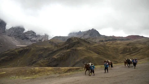 Native Peruvian riding on horses  in the Rainbow Mountain, Peru Stock Footage 125282592