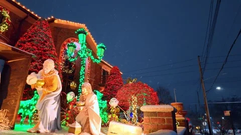 Nativity scene, luminous garlands and figurines at the street. Snow falls at the Stock Footage 342190754