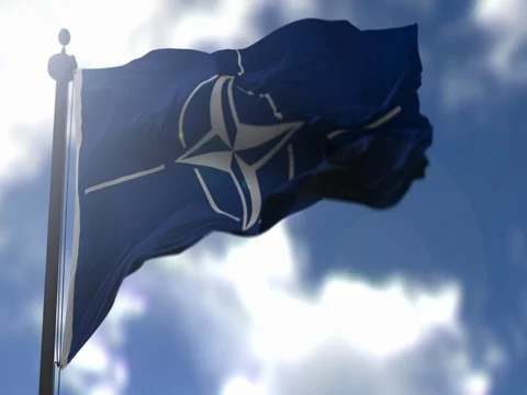 NATO Flag is Waving Against Blue Sky Stock Footage