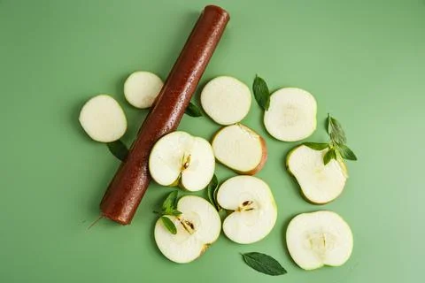 Natural apple fruit leather rolls with mint on green background Stock Photos