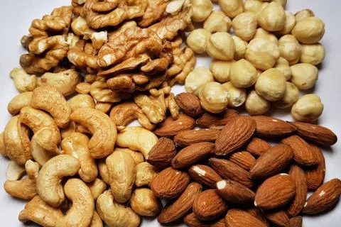 A natural background from different types of nuts is tiled with lots of close Stock Photos