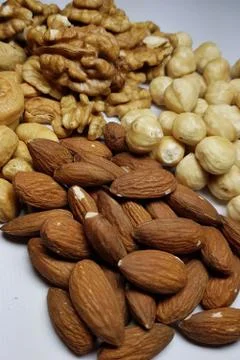 A natural background from different types of nuts is tiled with lots of close Stock Photos