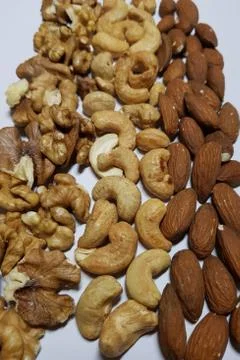 Natural backgrounds from different types of nuts are lined with rows Stock Photos