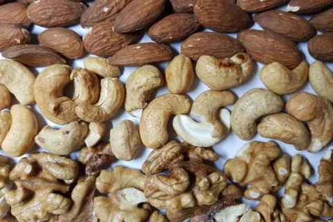 Natural backgrounds from different types of nuts are lined with rows Stock Photos