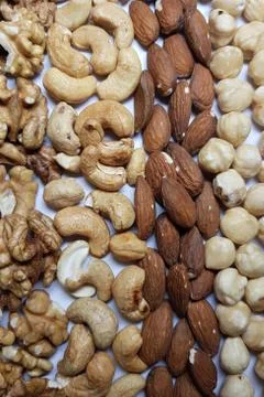 Natural backgrounds from different types of nuts are lined with rows Stock Photos
