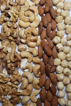 Natural backgrounds from different types of nuts are lined with rows Stock Photos
