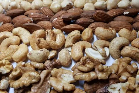 Natural backgrounds from different types of nuts are lined with rows Stock Photos