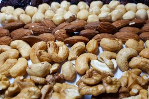 Natural backgrounds from different types of nuts are lined with rows Stock Photos