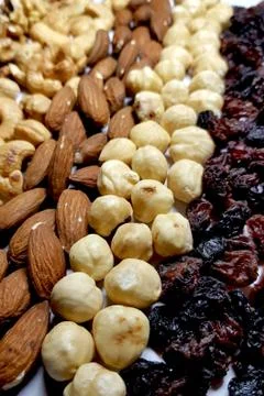 Natural backgrounds of different types of nuts and raisins are lined with row Stock Photos