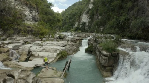 Natural, beautiful and empty waterfall at green wilderness valley - Low Aerial Stock Footage 114509236