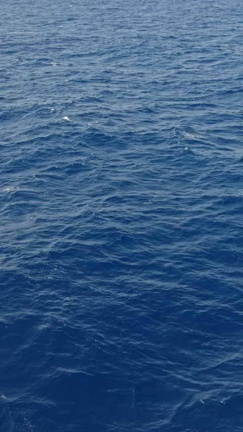 Natural blue atlantic ocean surface real time vertical video flying over esa Video stock 295003739