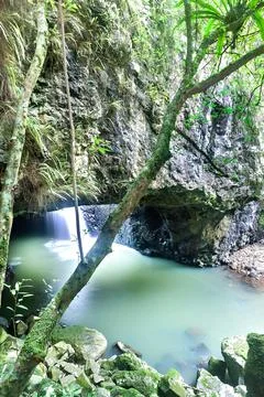 Natural bridge, including waterfall inside a dark stone cave Stock Photos