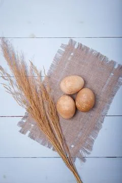 Natural brown colored Easter eggs on sack cloth on blue wooden background Stock Photos