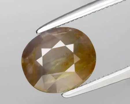 Natural brown sapphire gem on the background Stock Photos