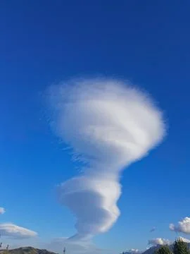 A natural cloud formation against a pristine blue sky accentuates its dramatic Stock Photos