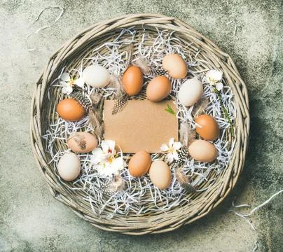 Natural colored eggs for Easter in basket over concrete background Stock Photos
