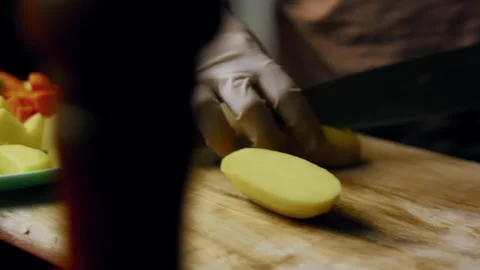 Natural cook peeling vegetables with a handheld peeler in macro, 4K Stock Footage 341108626