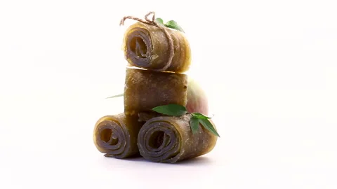 Natural dried apple snack rolls arranged with fresh fruit on white background Stock Footage 342520945