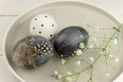 Natural dyed grey Easter eggs in a plate on rustic wooden background with g.. Stock Photos