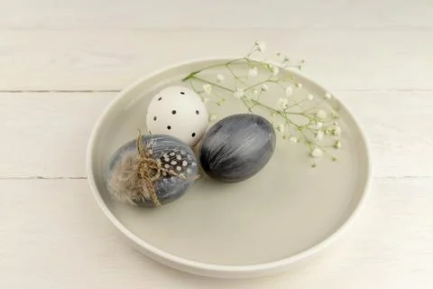 Natural dyed grey Easter eggs in a plate on rustic wooden background. High .. Stock Photos