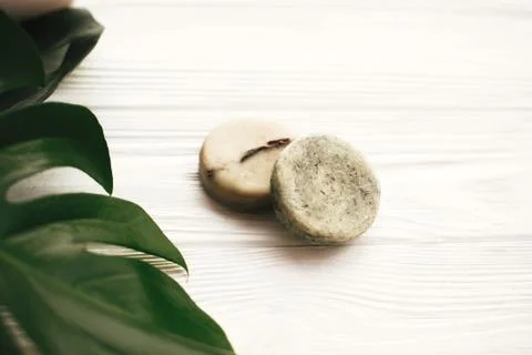 Natural eco friendly solid shampoo bar, green conditioner, soap on white wood 写真素材