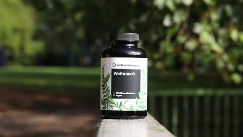 Natural elements frankincense supplement bottle in a park 库存影片 345256201