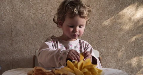 Natural food. Boy eats mango slices on plate. lunchtime snack of fruit Stock Footage 274877782