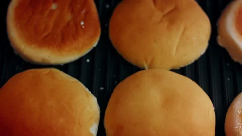 Natural four bread rolls toasting evenly in low angle, 4K Stock Footage 341117002