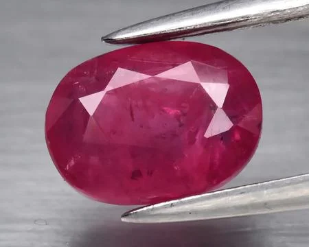 Natural gemstone red ruby on gray background 库存照片