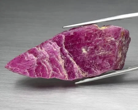 Natural gemstone red ruby on gray background 库存照片