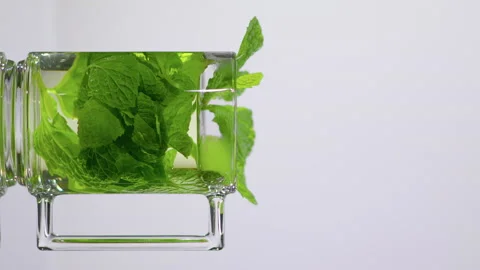 Natural green tea leaf wrapped in a transparent Cup. Pouring tea into glass Stock Footage 144477369