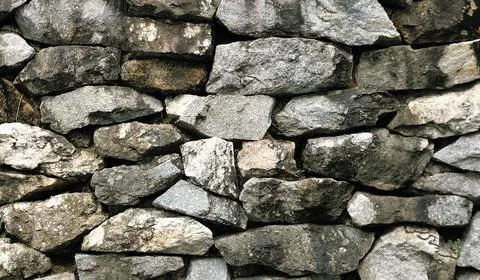 Natural grey stone wall texture, rough stacked stone background. Stock Photos