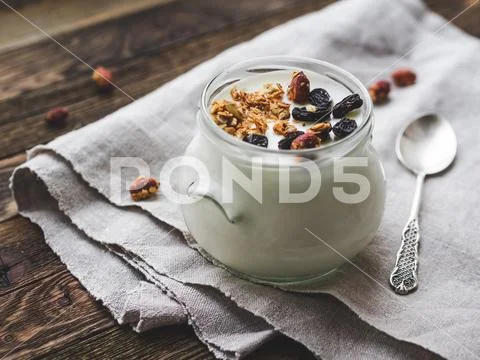 Natural homemade yogurt in a glass jar. Healthy food for breakfast with muesl Stock Photos