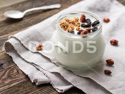 Natural homemade yogurt in a glass jar. Healthy food for breakfast with muesl Stock Photos