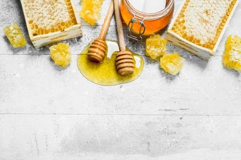 Natural honey in honeycombs with wooden spoons. Stock Photos