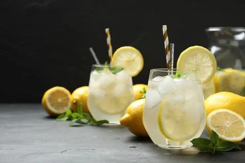 Natural lemonade with mint on grey table, space for text. Summer refreshing d Stock Photos
