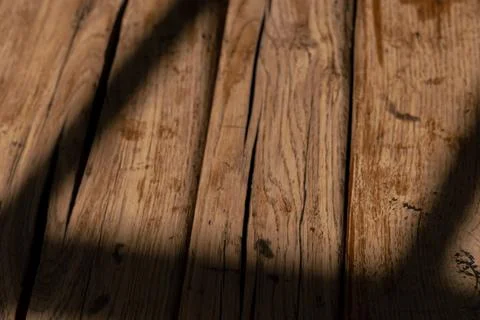 Natural light casting shadows across rustic wooden surface in a cozy indoor Foto stock