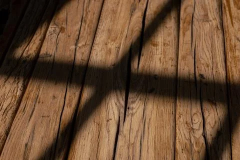 Natural light casting shadows across rustic wooden surface in a cozy indoor Stock Photos