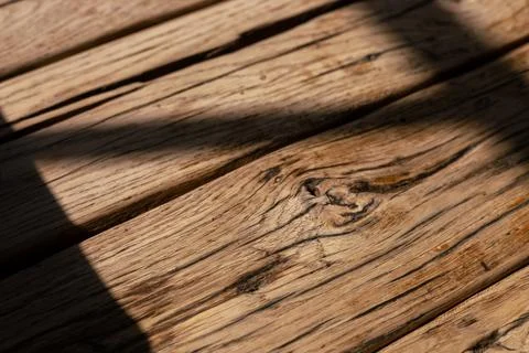 Natural light casting shadows across rustic wooden surface in a cozy indoor Stock Photos