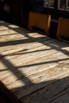 Natural light casting shadows across rustic wooden surface in a cozy indoor Stock Photos