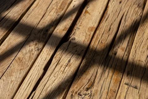 Natural light casting shadows across rustic wooden surface in a cozy indoor Foto stock