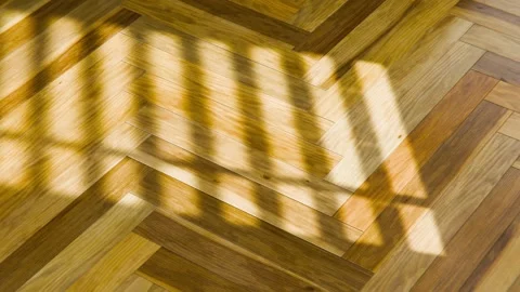 Natural light creates moving shadows of a window on a herringbone parquet floor Stock Footage 306761500