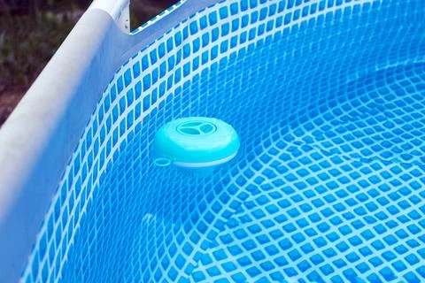 Natural light. frame pool. a container with solid tablets floats in the pool  Stock Photos