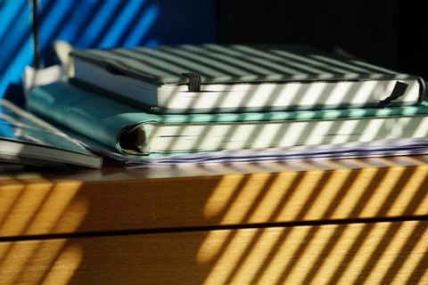 Natural light streams through window blinds, casting a rhythmic pattern of shado Stock Photos