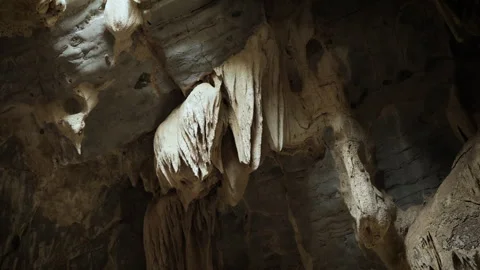 Natural limestone cave texture with stalactites and stalagmites in darkness. Stock Footage 321703371
