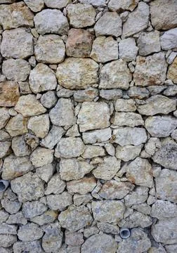 Natural limestone wall texture with sturdy rough stone arrangement Stock Photos