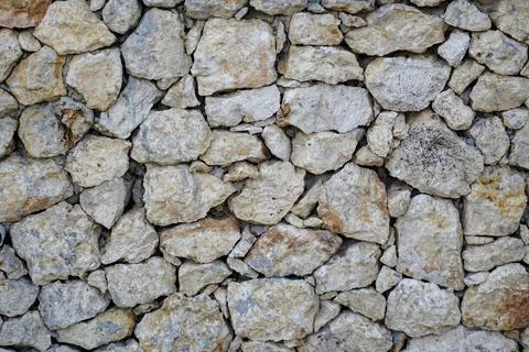 Natural limestone wall texture with sturdy rough stone arrangement Stock Photos