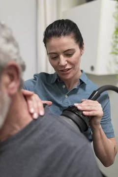 Natural medicine practitioner treating client with shoulder pain Stock Photos